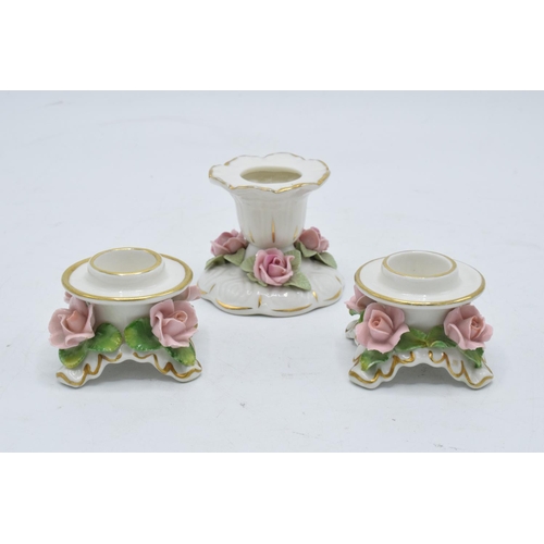 95L - A collection of early 20th century pottery candlesticks with raised floral decoration to include a D... 