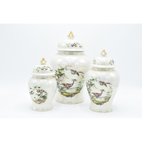 14 - A trio of graduated biscuit barrels/ ginger jars by Sadler with a birds and foliage scene with a lus... 