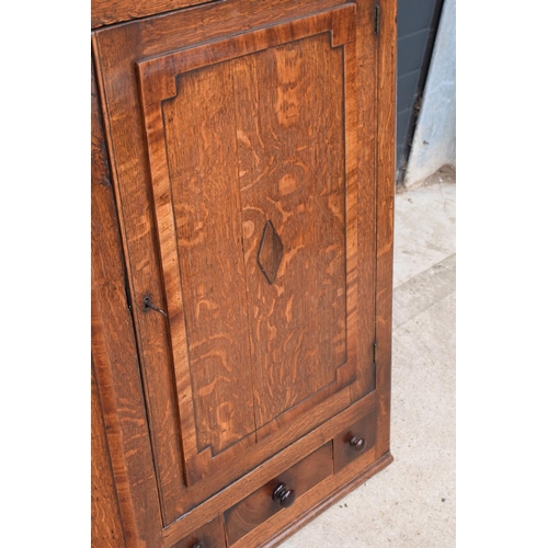 107 - A Georgian period oak corner cupboard with raised sections and a single drawer. 128cm tall, 82cm at ... 