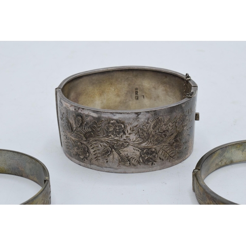 328 - A collection of silver bangles / bracelets with floral decorations. 79.5 grams. In good condition. S... 