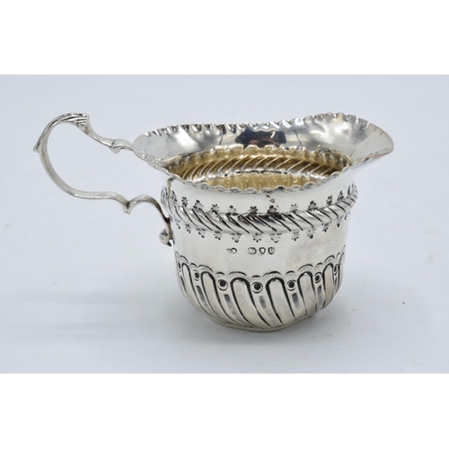 333 - An ornate silver cream jug / sauce jug. London 1890.  53.7 grams. In good condition with some dents ... 