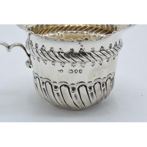 333 - An ornate silver cream jug / sauce jug. London 1890.  53.7 grams. In good condition with some dents ... 