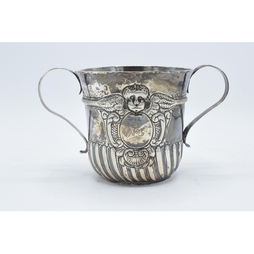 351 - A large silver porringer decorated with an embossed cherub decoration. 339.7 grams. In good conditio... 