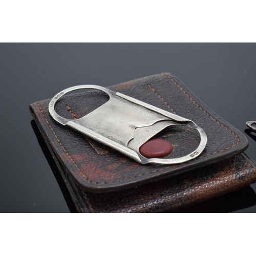 390 - A silver cigar cutter in a leather case (Birmingham 1909) together with a steel example in the form ... 