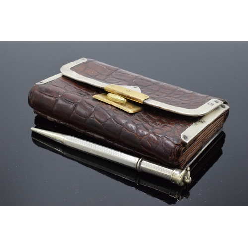 394 - A silver mounted crocodile leather purse with a silver cased pencil. London 1889.