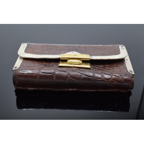 394 - A silver mounted crocodile leather purse with a silver cased pencil. London 1889.