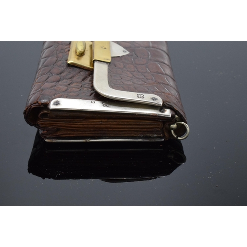 394 - A silver mounted crocodile leather purse with a silver cased pencil. London 1889.