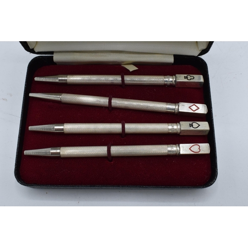 399 - A sterling silver set of 4 bridge pencils with the tops of the pencils depicting the 4 suits. 9cm lo... 