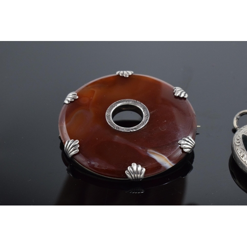 555 - A silver and agate circular brooch together with an agate set locket-back pendant (2).