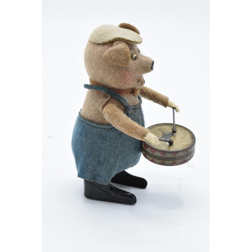 182 - A Schuco circa 1930s clockwork toy figure in the form of a pig with a drum. Based on the Three Littl... 