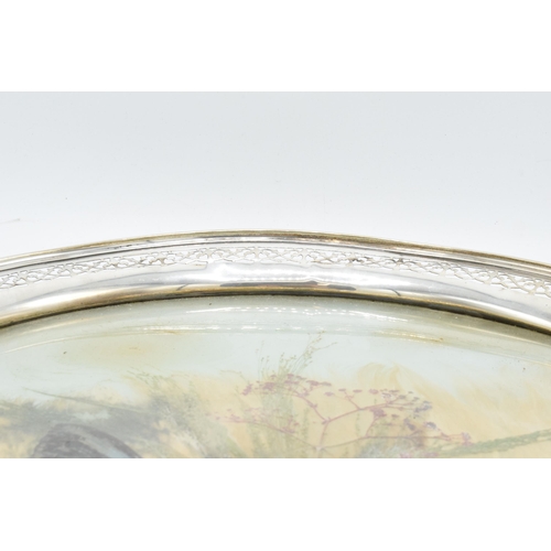 389B - An unusual sterling silver circular tray with pierced edges decorated with dried glass and foliage. ... 