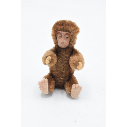 90A - A 1930s/ 1940s miniature Schuco monkey, mohair body,
painted tin-plate face, rotating head and
artic... 