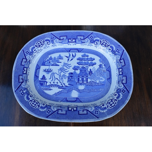 110A - A large 19th century blue and white meat platter with transfer decoration of idealised landscape wit... 