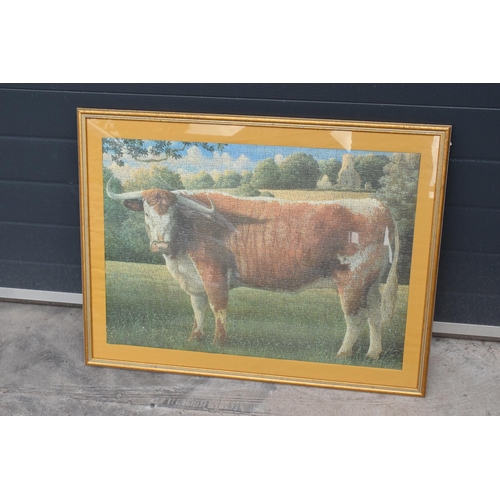 210C - A framed jigsaw of a Longhorn cow in a wooden frame