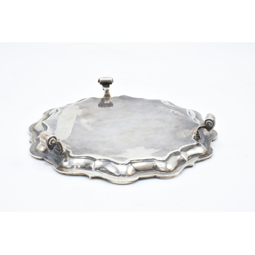 184 - A hallmarked silver salver with shaped edge raised on three feet. Hallmarked for Sheffield 1926. Mad... 