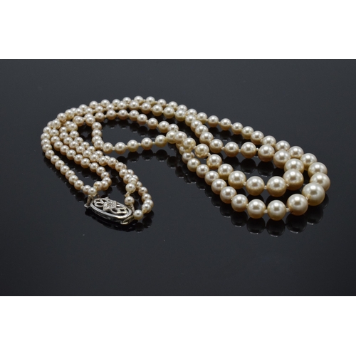 251 - A double string imitation pearl necklace set with a white 9ct gold clasp.