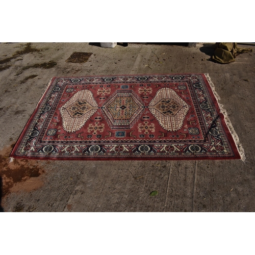 285 - A 20th century carpet decorated in a red / pink colour. Approx 276 x 180cm.