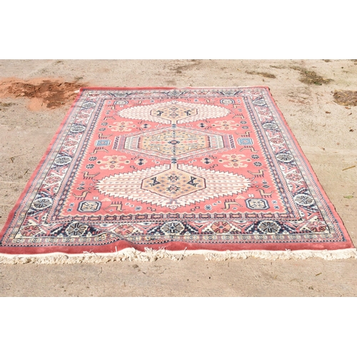 285 - A 20th century carpet decorated in a red / pink colour. Approx 276 x 180cm.