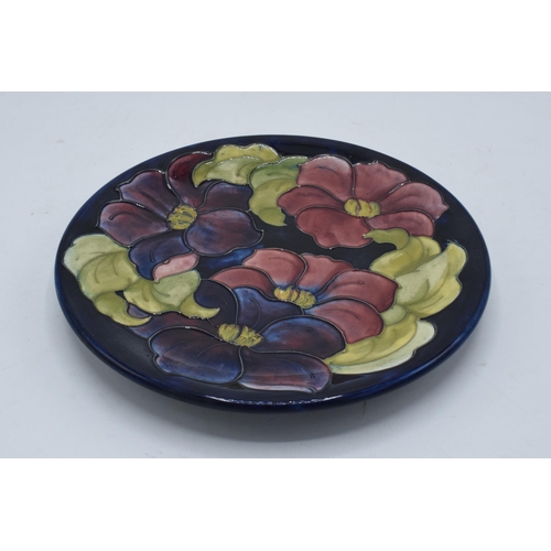 95 - A large Moorcroft 26cm diameter plate in the Hibiscus design on a blue background. In good condition... 