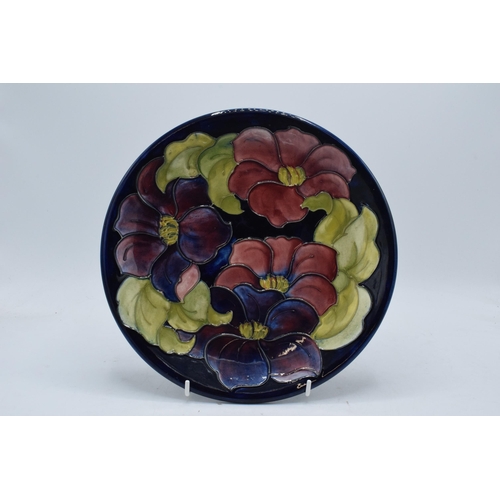 95 - A large Moorcroft 26cm diameter plate in the Hibiscus design on a blue background. In good condition... 