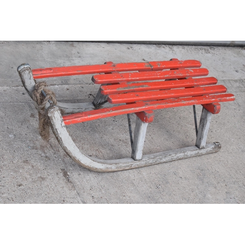 276 - A vintage wooden child's sledge painted in red by Henry A Murton of Newcastle. 82cm long. In good co... 