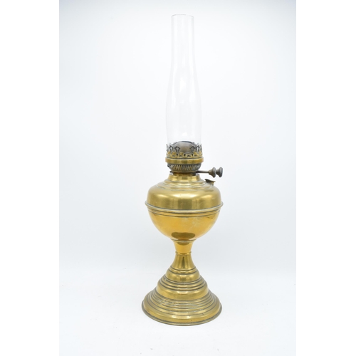 312 - A 20th century brass oil lamp with an associated shade. 32cm tall without shade. 'Best English Make'