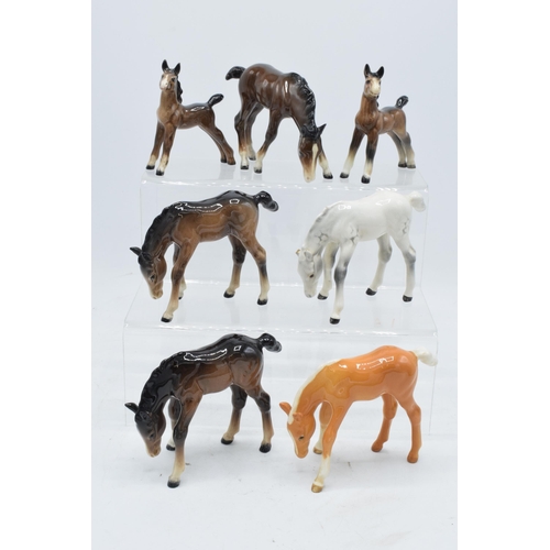 164 - A collection of Beswick ponies to include grazing pony 946 in palomino, 3 brown examples and a dappl... 