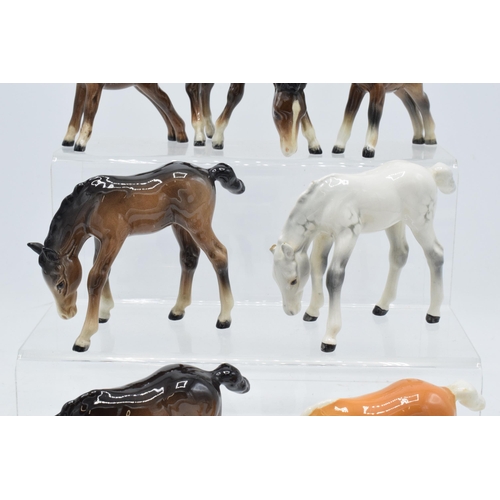 164 - A collection of Beswick ponies to include grazing pony 946 in palomino, 3 brown examples and a dappl... 