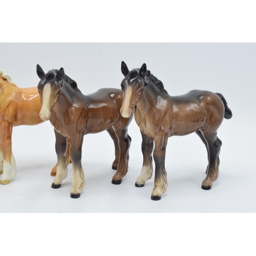 165 - A collection of Beswick shire foals 1053 to include 2 brown examples and 2 palomino examples (4). In... 