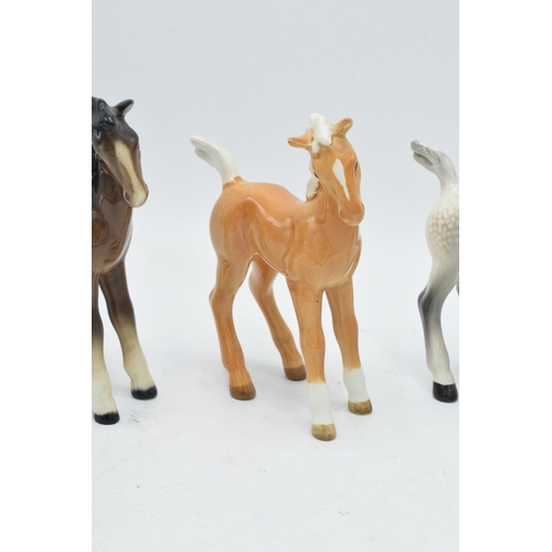 167 - A collection of Beswick comical-type foal 728 in various colourways to include brown, grey and palom... 