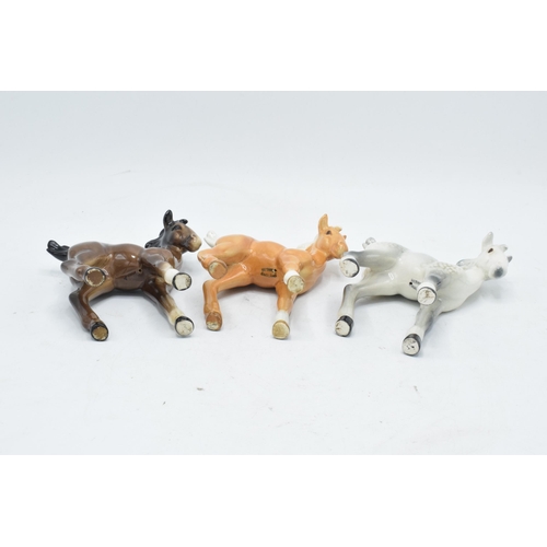 167 - A collection of Beswick comical-type foal 728 in various colourways to include brown, grey and palom... 