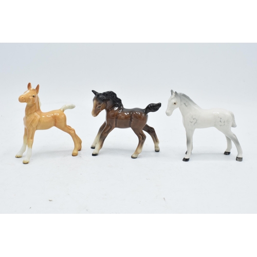 168 - A collection of Beswick horses to include grey thoroughbred foal, brown stretched foal facing left a... 