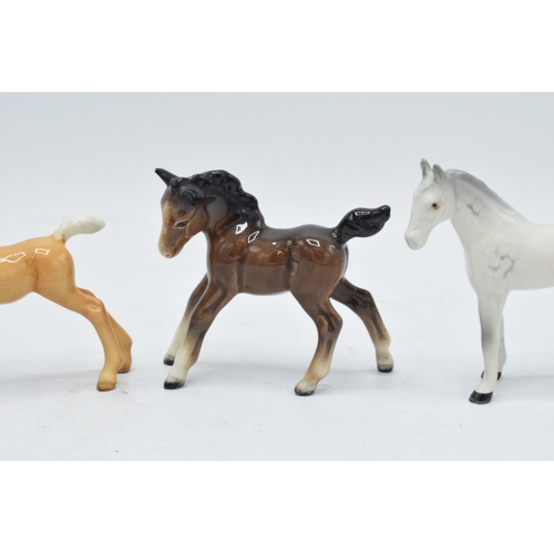 168 - A collection of Beswick horses to include grey thoroughbred foal, brown stretched foal facing left a... 