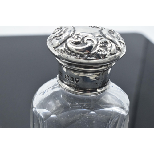 210 - Edwardian glass scent bottle with a silver screw top lid with repousse decoration. London 1904. 10cm... 