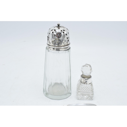 234 - A collection of silver items to include a silver topped shaker, a perfume bottle with a silver neck,... 