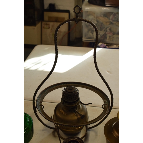 287 - A collection of 20th century oil lamps and burners of various forms to include examples with swingin... 