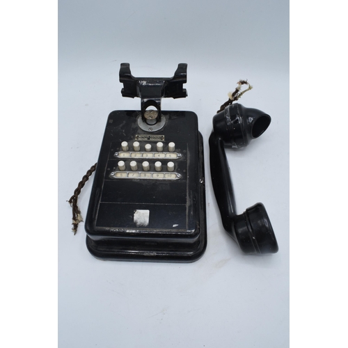 328 - A 20th century wall mounted telephone for internal use with handset. There is some damage to the bot... 