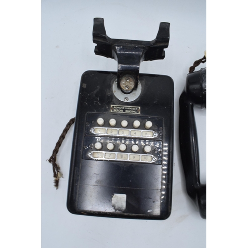 328 - A 20th century wall mounted telephone for internal use with handset. There is some damage to the bot... 