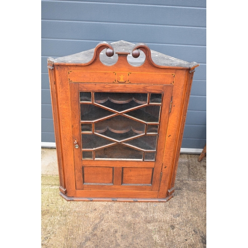 334 - A 19th century inlaid corner cabinet with astragal glazed door with swan neck pediment. 106cm tall. ... 