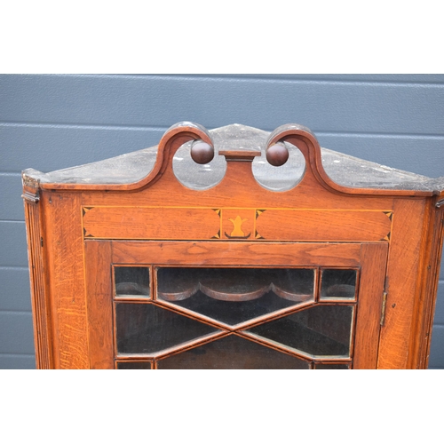 334 - A 19th century inlaid corner cabinet with astragal glazed door with swan neck pediment. 106cm tall. ... 