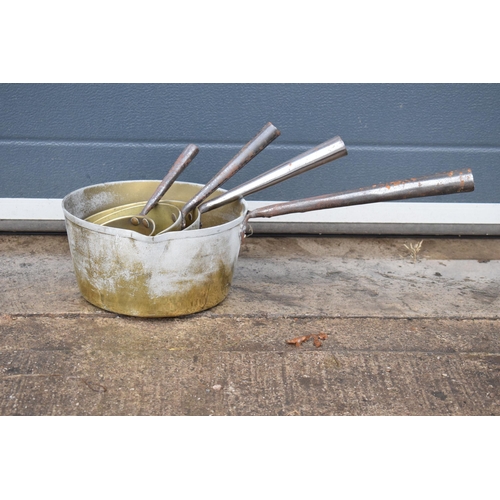 341 - An antique set of brass and metal handled saucepans, 56cm longest (4 pans).