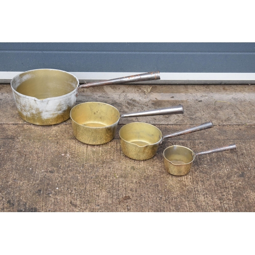 341 - An antique set of brass and metal handled saucepans, 56cm longest (4 pans).