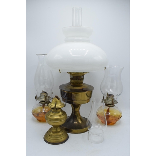 347 - A collection of vintage oil lamps to include brass examples with associated shades and chimneys (4).... 