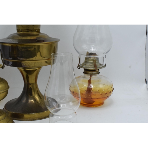 347 - A collection of vintage oil lamps to include brass examples with associated shades and chimneys (4).... 