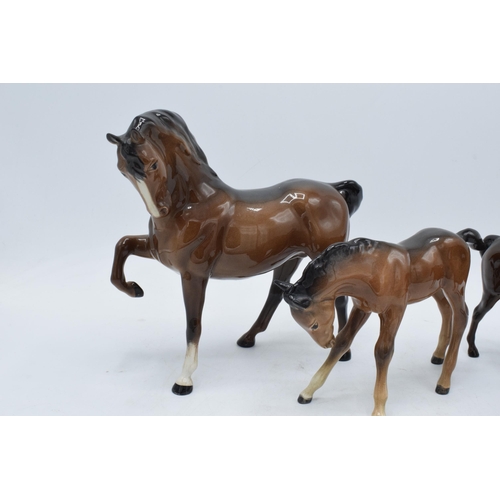 145 - A trio of brown Beswick horses to include leg tucked horse 1549, mare facing right 991 and a large s... 