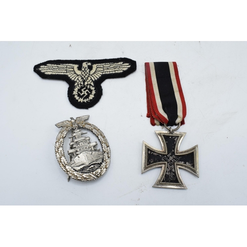 273 - A collection of German Militaria to include a WW2 iron cross and ribbon, a reproduction Nazi cap bad... 