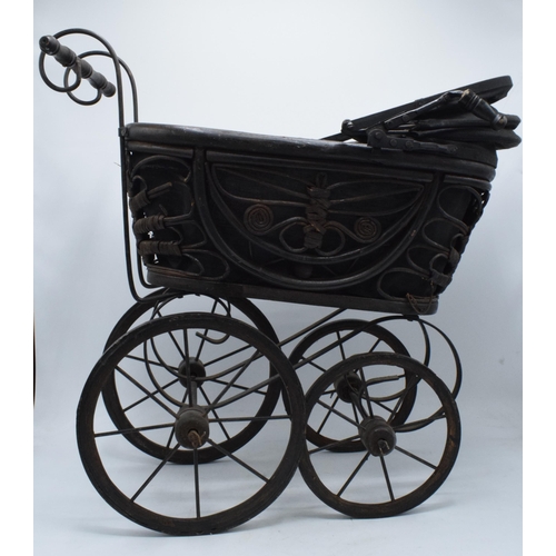 316 - Am early to mid 20th century ornate dolls pram on wooden and metal wheels. 58cm tall.