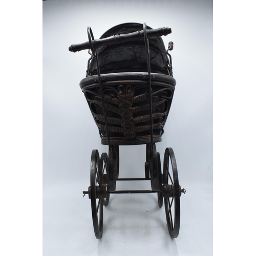 316 - Am early to mid 20th century ornate dolls pram on wooden and metal wheels. 58cm tall.