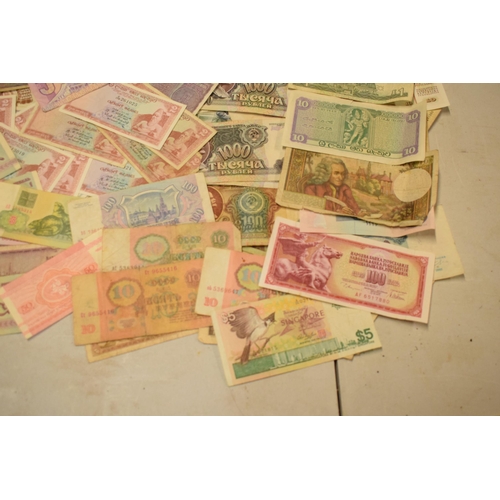 317 - A mixed collection of bank notes from across the world to include examples from Singapore, Ghana, Fr... 