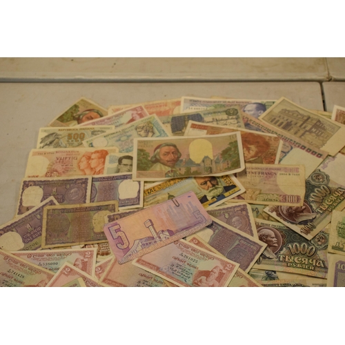 317 - A mixed collection of bank notes from across the world to include examples from Singapore, Ghana, Fr... 